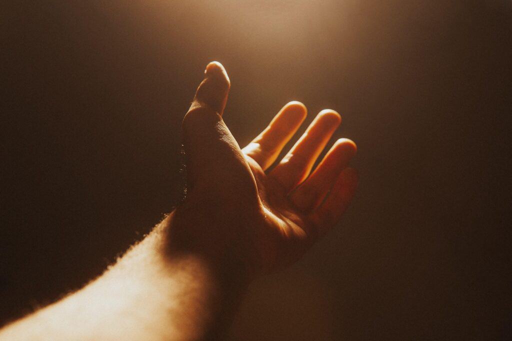 Hand reaching toward the light for help