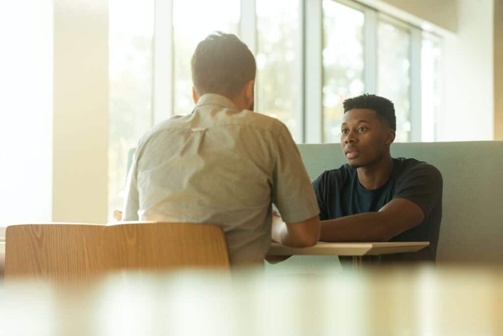 Two guys sitting having a serious conversation with one another